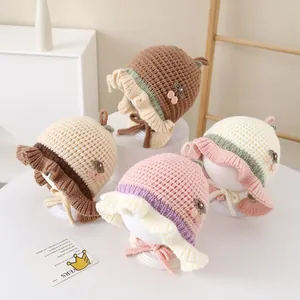 Dettaglio di cappelli per neonati in maglia con bordi a conchiglia e ricamo a ciliegia