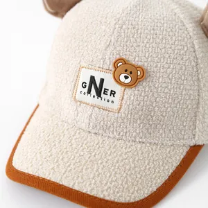 Close-up of beige fleece kids baseball cap with cute bear ears and GNER patch details
