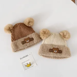 Knitted baby winter hat with double fur pom-poms and cute bear patch for ear protection