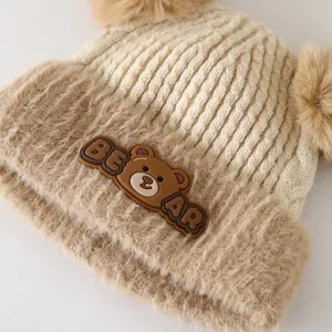 Winter knitted baby bear hat with pom poms and warm plush lining in beige and brown