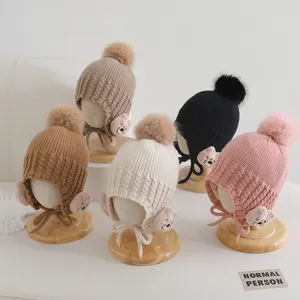 Dettaglio set di cappelli in maglia con orsetto, pompon e paraorecchie in cinque colori