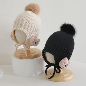 Dettaglio di cappelli in maglia per bambini con pompon e toppe a forma di orso