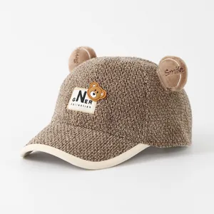 Detailed macro of kids brown plush baseball cap with 3D ears and bear patch