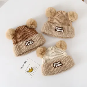 Detailed knit texture of baby beanies with fluffy pom poms and soft faux fur trim decor