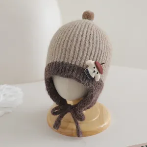 Close-up of knit texture and cute puppy applique on a brown baby earflap hat