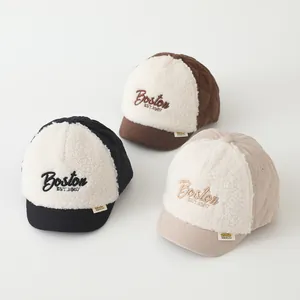 Detailed view of three baby baseball caps in black, brown, and beige with Boston embroidery