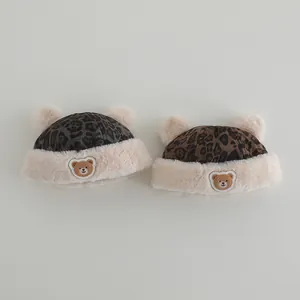 Close-up of baby leopard print hats with plush ears and cute bear embroidery detail