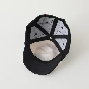 Inside view of black baseball cap showing warm quilted lining and reinforced seams