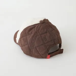 Detail view of winter brown quilted cap with warm white lamb wool lining and adjustable strap