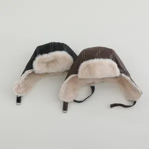 Detalle de gorro de aviador para niños con forro de piel sintética y costuras blancas