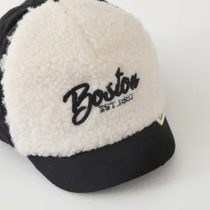 Detail of Boston embroidery on white fleece and black quilted diamond pattern baby cap