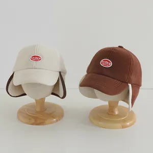 Detailed view of fleece baseball hats with ear flaps and embroidery for kids