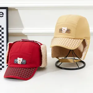 Détail de bonnets d'aviateur d'hiver pour enfants avec motif à carreaux et polaire