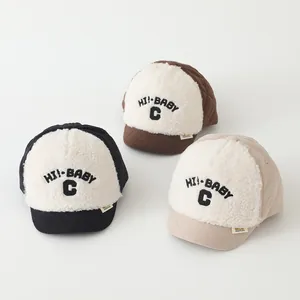 Detailed view of quilted baby baseball caps in black, brown and beige with fleece text