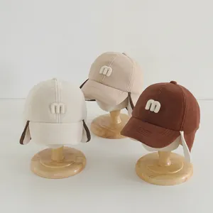 Detailed view of fleece winter baseball hats with earflaps and M letter embroidery