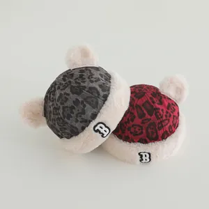 Detail of baby leopard print winter hats with plush trim in gray and red colors