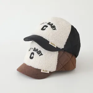 Close-up of baby winter baseball caps featuring plush fleece and embroidered letters