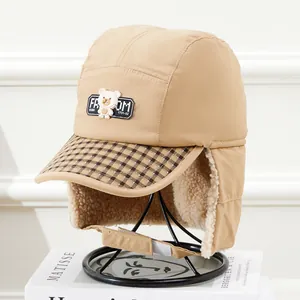 Détail du chapeau trappeur kaki chaud avec doublure polaire et écusson ours sur support
