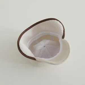 Close-up of baby baseball hat featuring warm white faux shearling lining and earflaps