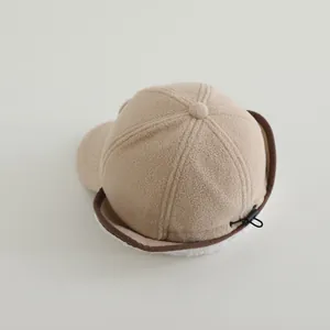 Close-up of beige fleece winter hat with earflaps and adjustable drawstring cord