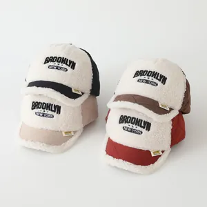 Close-up of winter sherpa baseball caps showing quilted fabric and embroidered letters