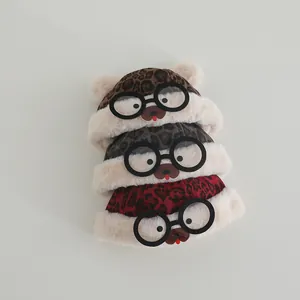 Detail of plush leopard print baby winter hats with cute bear ears and decorative glasses