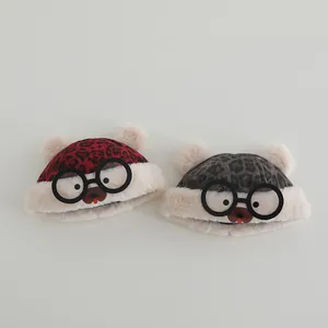Close-up of baby warm hats featuring cute bear design and fluffy leopard pattern details