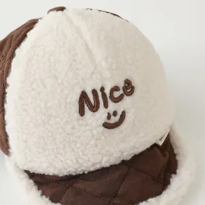 Close-up of winter baby cap featuring brown quilted fabric and white sherpa fleece detail