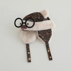 Detail of leopard print baby winter hat featuring plush fur lining and cute bear glasses