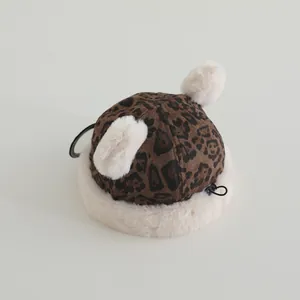 Detail of leopard print baby winter hat with faux fur trim and fluffy double pom poms