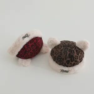 Detail of plush baby beanies with leopard print patterns and cute fur pom-pom ears