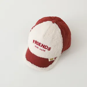 Detailed shot of quilted red kid baseball cap with white fleece panels and embroidery