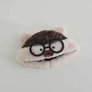 Detail of plush baby leopard print hat featuring cute bear ears and glasses design