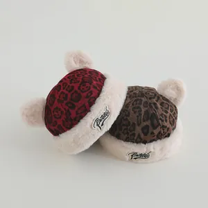 Detail of red and brown leopard print winter baby hats with fluffy ears and soft lining