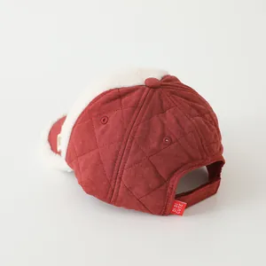 Detail of red quilted child baseball cap featuring white faux lamb wool lining and adjustable strap