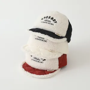 Detail of fleece baby baseball caps with quilted panels and embroidery in three colors