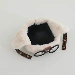 Detail of baby pilot hat featuring plush material, glasses decor, and leopard straps