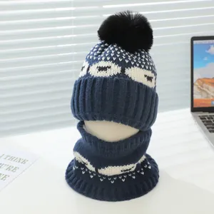 Détail de l'ensemble bonnet et tour de cou tricotés bleu marine avec pompon noir