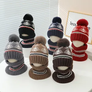 Detail of winter knit children's hat and scarf set with pompom and Nordic snowflake pattern
