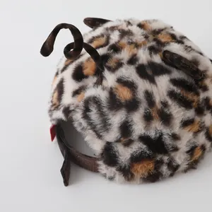 Detail of leopard print faux fur baby hat featuring plush animal ears and adjustable strap