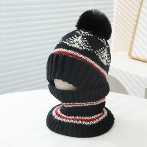 Detail of children's thick knitted hat and neck warmer set in black with white geometric patterns