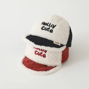 Close-up of soft lamb wool baby baseball caps with Hello Cute embroidery and texture