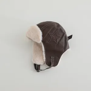 Close-up of brown leather aviator hat with faux fur lining and star embroidery
