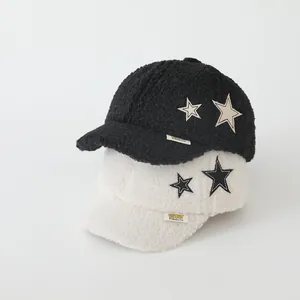 Dettaglio dei cappellini da baseball in pile per neonati con toppa a forma di stella
