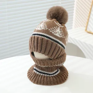 Detail of warm winter knit hat and neck warmer set with fluffy pompom and mountain pattern