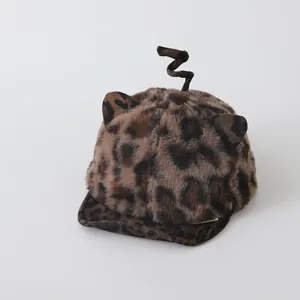 Detail of leopard print baby hat with plush cat ears and spiral tail decoration