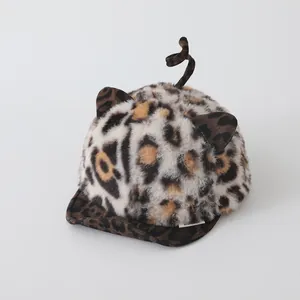 Detail of baby leopard print plush hat with soft animal ears and curly tail decoration