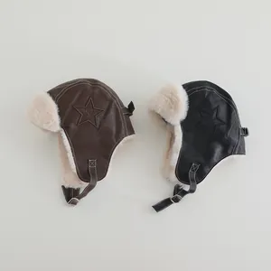 Detail of brown and black leather trapper hats with faux fur lining and star patch