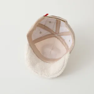 Close-up of quilted fabric texture and warm faux shearling lining on baby baseball cap