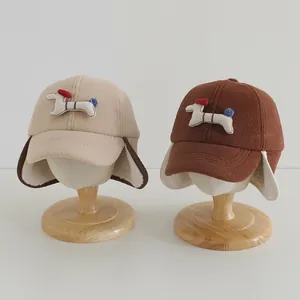 Detail von warmem Plüschfutter und niedlichen Hunde-Patches an Kinder-Ohrenschützermützen